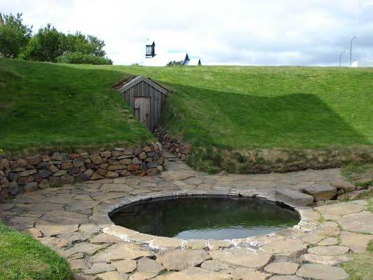 In 13th century Iceland, Snorri Sturluson built a farmhouse and this heated pool, called Snorralaug. The site was restored in 1858 and 1959. A tunnel dug behind the door allowed Snorri to move quickly from the pool to his farmhouse. The outdoor pool and perhaps the farmhouse were heated by steam and hot water flowing through conduits from a nearby hot spring. The hot water enters the pool from the ditch on the right. Photo from Snorralaug, Wikimedia Commons