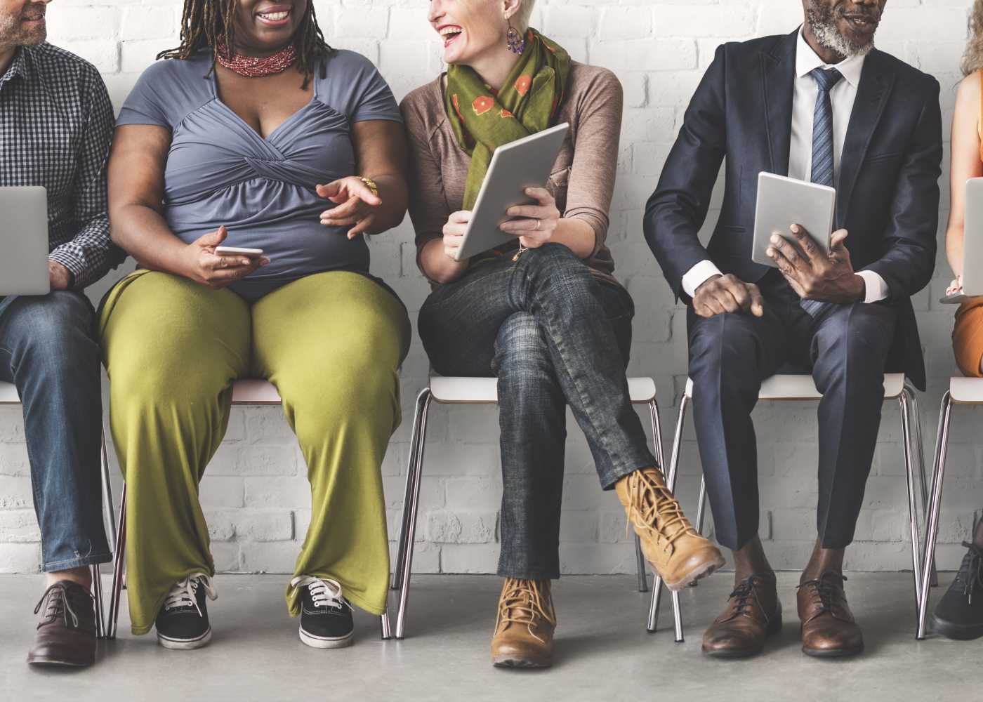 Stock photo of a diverse group of people sharing information on their devices.