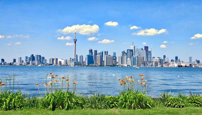 A photo of downtown Toronto with the CN Tower in the background, taken from across Lake Ontario.