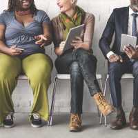 Stock photo of a diverse group of people sharing information on their devices.